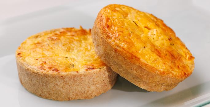 Fotografia de dois salgados assados feitos com massa podre e recheio cremoso de Requeijão NESTLÉ, champignon e cebolinha.