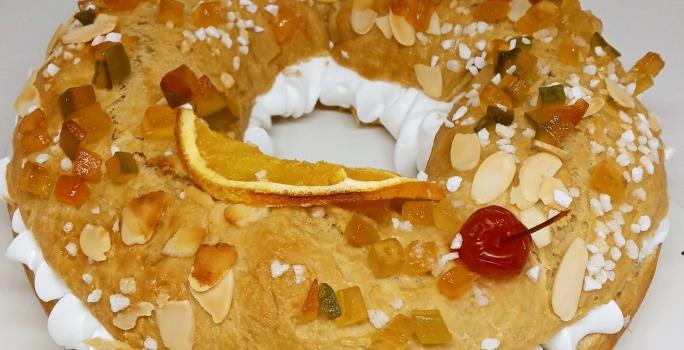 Fotografia de um pão assado, dorado e recheado em formato de rosquinha no tamanho maior.