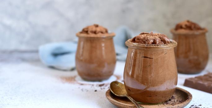 Foto da receita de Mousse de Chocolate Zero Lactose. Observa-se três potes de vidro transparentes com a mousse de chocolate dentro.