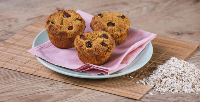 Foto da receita de Muffin de Maçã e Manga. Observa-se 3 muffins em cima de um guardanapo rosa e um prato azul.